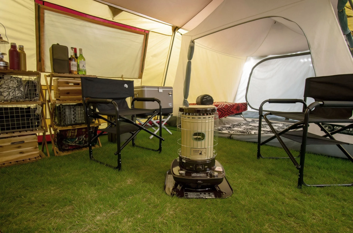 テント内に設置された石油ストーブとキャンプギア
