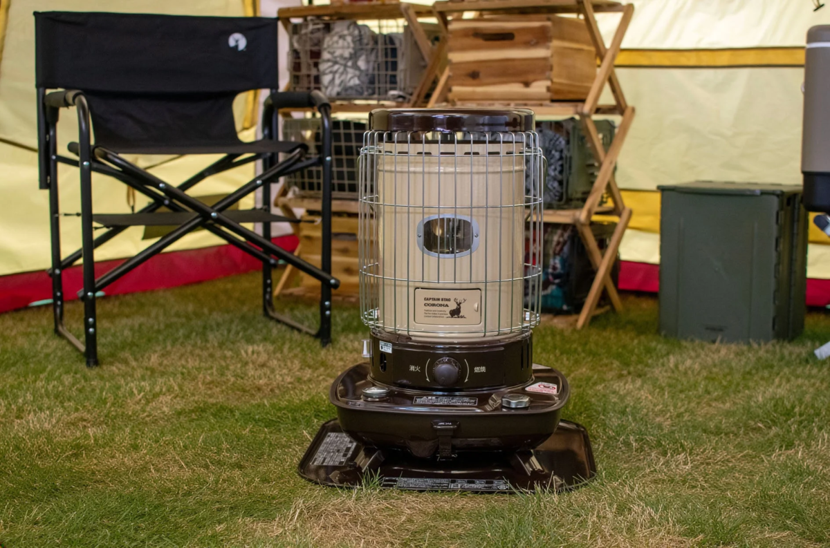 キャンプサイトに設置された石油ストーブ、テント、チェア